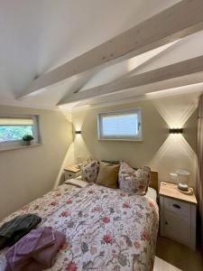 a bedroom with a large bed and two windows at Ferienhaus am See in Staupitz