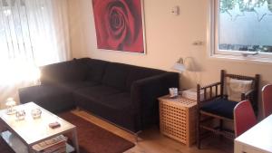 a living room with a black couch and a table at Jachtslot Chalet J8 in Doornspijk
