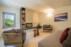 a living room with a couch and a chair and a window at Villa Immersa Tra Le Vigne Con Piscina Riscaldata in Castiglione Tinella