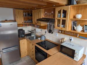 een keuken met houten kasten en een roestvrijstalen koelkast bij Apartment Lucy in Vysoké Tatry +17 foto's