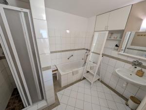 een witte badkamer met een bad en een wastafel bij Apartment Lucy in Vysoké Tatry