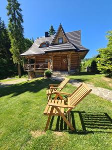 a wooden bench in front of a log cabin at Bacówka Polanki in Obidowa