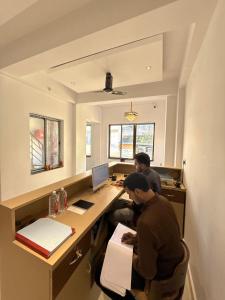 two men working at a desk in an office at HOTEL ATULYAM STAYs PREMIUM in Prayagraj +74 photos