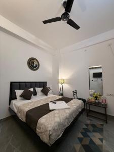a bedroom with a bed with a ceiling fan at HOTEL ATULYAM STAYs PREMIUM in Prayagraj