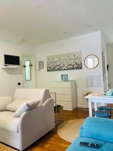 a living room with a white couch and a table at La finestra sul lago in Malgrate