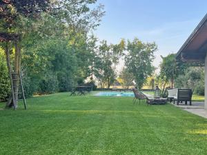 a yard with a swimming pool and chairs and a lawn at Il Cortile Agriturismo in Borgonovo Val Tidone