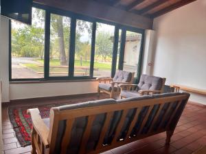 a living room with two chairs and a couch and windows at Il Cortile Agriturismo in Borgonovo Val Tidone