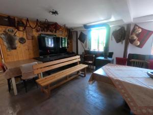 a living room with a television and a table and a couch at Chergata Guest House in Zheglitsa