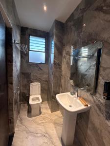 a bathroom with a sink and a toilet at HOTEL ATULYAM STAYs PREMIUM in Prayagraj +85 photos