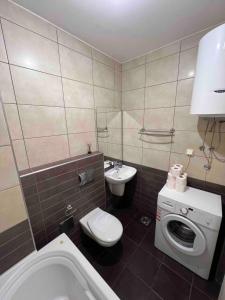 a bathroom with a toilet a sink and a washing machine at Maya bay in Kotor