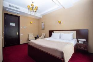a hotel room with a large bed and a chandelier at Marionn Hotel in Tbilisi City +76 photos