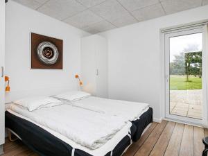 a bedroom with a large bed and a window at 5 star holiday home in Ringkøbing in Ringkøbing