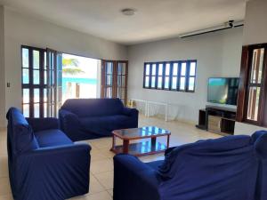 a living room with blue couches and a tv at Sun Paradise - Ipioca in Maceió