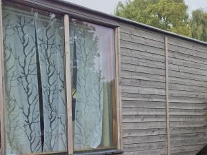 una finestra in una casa con alberi sopra di Haus Evelynchen auf Rädern Deutschhof a Deutschhof