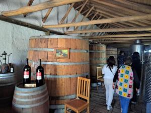 a group of people walking through a wine cellar at Hotel Los Artesanos in Villa Alegre