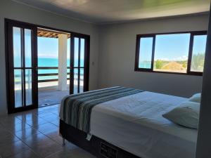 a bedroom with a bed with a view of the ocean at Sun Paradise - Ipioca in Maceió +47 photos