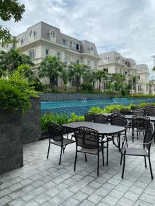 Hạ Long Sapphire Premium في ها لونغ: فناء فيه طاولات وكراسي امام مبنى