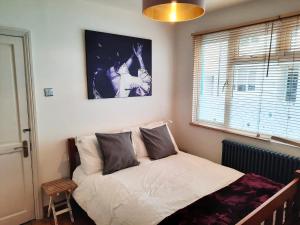 a bed sitting in a bedroom with a window at Ground floor double with en suite shower room in Brighton & Hove +13 photos