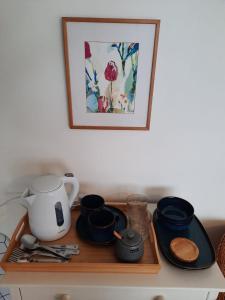 a tray with a tea kettle and utensils on a counter at Ground floor double with en suite shower room in Brighton & Hove
