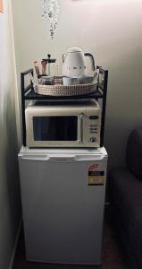 a microwave sitting on top of a refrigerator at Guest suite in Phillip Island in Cape Woolamai