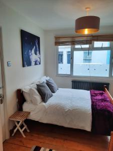 a bedroom with a large white bed and a window at Ground floor double with en suite shower room in Brighton & Hove