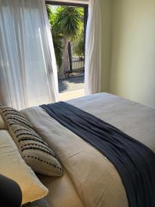 a bed with pillows in a room with a window at Guest suite in Phillip Island in Cape Woolamai