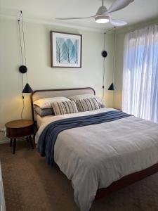 a bedroom with a large bed and a ceiling fan at Guest suite in Phillip Island in Cape Woolamai