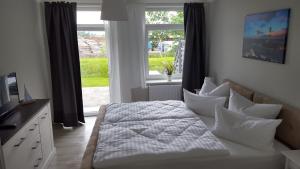 a bedroom with a bed with pillows and a window at Pension Fischerjung in Rostock
