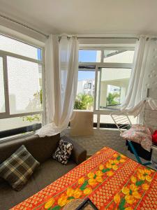 a living room with a couch and two windows at Apparemment asilah marina golf in Asilah