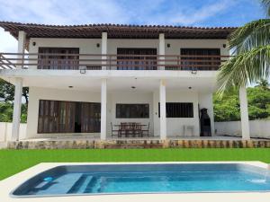 a house with a swimming pool in front of it at Sun Paradise - Ipioca in Maceió