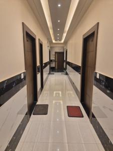 a corridor of a building with doors and mats at Guru Kripa Dham in Vrindāvan
