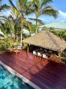 eine Hütte mit Stühlen und einem Tisch und einem Pool in der Unterkunft Tropical Pool Villa in Orient Bay