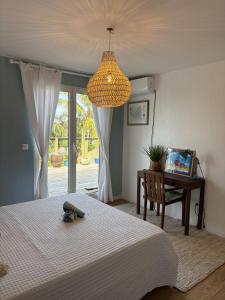 ein Schlafzimmer mit einem Bett, einem Schreibtisch und einem Kronleuchter in der Unterkunft Tropical Pool Villa in Orient Bay