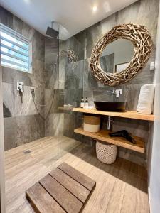 ein Badezimmer mit Waschbecken und Spiegel in der Unterkunft Tropical Pool Villa in Orient Bay