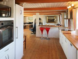 a kitchen and living room with red stools at 4 star holiday home in Hadsund in Hadsund