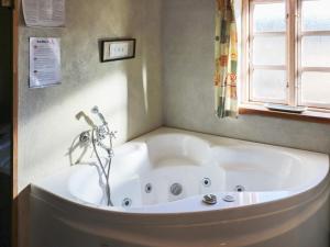 a white tub in a bathroom with a window at 4 star holiday home in Hadsund in Hadsund