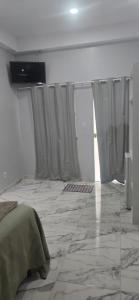 a bedroom with curtains and a bed in a room at Pousada Meu Refúgio 