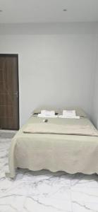 a bed in a bedroom with a white wall at Pousada Meu Refúgio  +4 photos