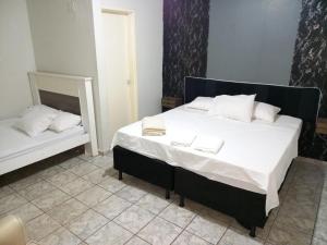 a bedroom with a large bed and a mirror at Pousada Roosevelt- suíte 1 in Uberlândia