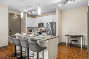 a kitchen with a bar with chairs and a table at Monarch Apartments 15m to Parks, Pet Friendly, Free Parking by Heavenly Homes in Orlando