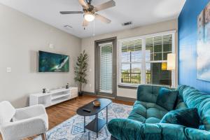 a living room with a blue couch and a table at Monarch Apartments 15m to Parks, Pet Friendly, Free Parking by Heavenly Homes in Orlando