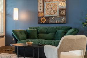 a green couch in a living room with a table at Monarch Apartments 15m to Parks, Pet Friendly, Free Parking by Heavenly Homes in Orlando