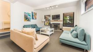 a living room with two couches and a tv at Carlton Place in Cowes