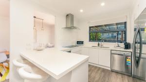 a white kitchen with a sink and a refrigerator at Carlton Place in Cowes