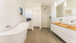 a white bathroom with two sinks and a tub at Carlton Place in Cowes +10 photos