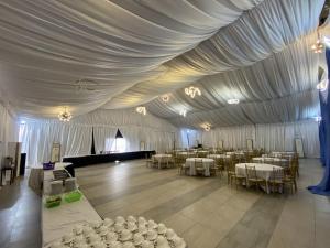 a room with a tent with tables and chairs at Bolton White Residence in Abuja