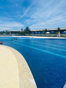 a large swimming pool with blue water in a resort at Refúgio com Lazer de Resort in Estância