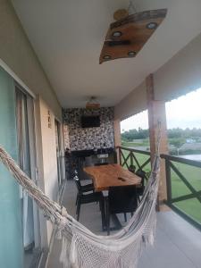 a hammock on a balcony with a table and chairs at Refúgio com Lazer de Resort in Estância
