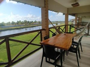 a wooden table and chairs on a balcony with a hammock at Refúgio com Lazer de Resort in Estância