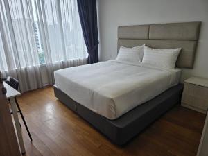 a bedroom with a large bed with white sheets at Vortex suites klcc by KAZI in Kuala Lumpur +5 photos